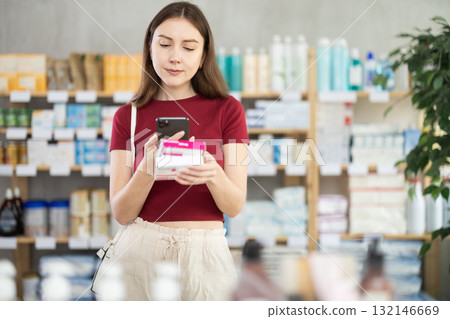 Woman scans a package of paracetamol Woman scans a package of paracetamol 132146669