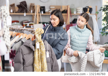 Teenage girl and her mother choose down jacket Teenage girl and her mother choose down jacket 132146760