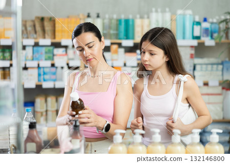 Mother and daughter choosing cough syrup at the pharmacy Mother and daughter choosing cough syrup at the pharmacy 132146800