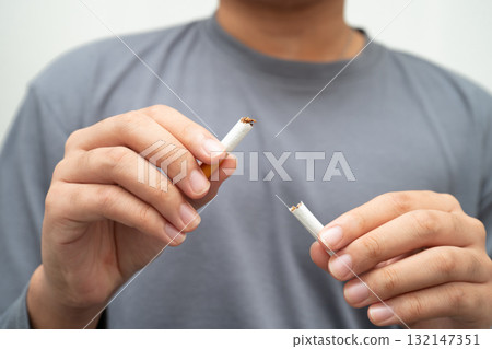 Quit smoking, Asian teenage man breaking destroy cigarette in hand. 132147351