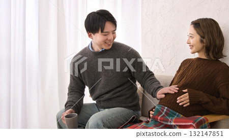 一對年輕夫婦在沙發上休息,孕婦 一對年輕夫婦在沙發上休息,孕婦 132147851