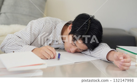 Asian man sleeping while studying Asian man sleeping while studying 132147998