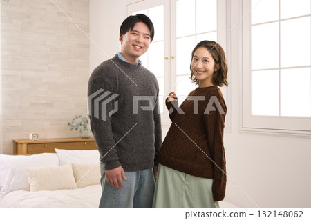 一對年輕夫婦站在窗邊，一名孕婦 132148062