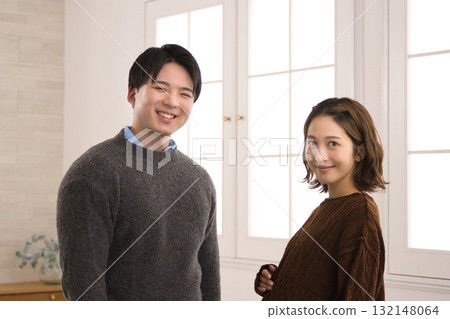 一對年輕夫婦站在窗邊,一名孕婦 一對年輕夫婦站在窗邊,一名孕婦 132148064