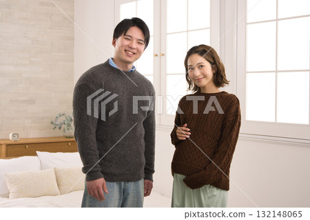 一對年輕夫婦站在窗邊，一名孕婦 132148065