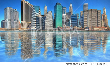 City skyline reflecting on water under a clear blue sky. Urban landscape and architecture. 132148949