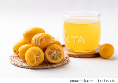 Fresh kumquats fruit and juice on white background Fresh kumquats fruit and juice on white background 132149510