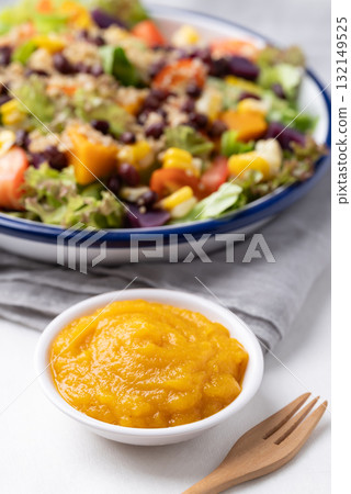 Healthy vegetable salad bowl and pumpkin dressing on white background. Vegan and plant-based food 132149525