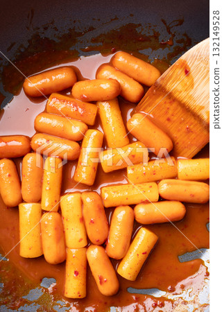 Tteokbokki (simmered rice cake) and sausage with spicy sauce in cooking pan, Korean food 132149528