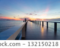 Walkway extending into calm sea at twilight. 132150218