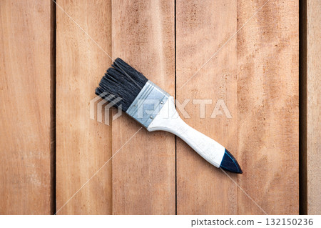 Paint brush and wood material in construction work. 132150236