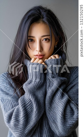 Portrait of a smiling woman wearing a gray knit 132150295