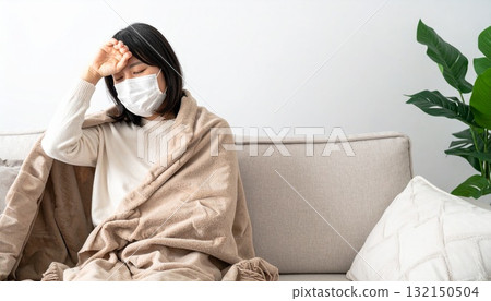 一名戴著口罩、抱著頭測量體溫的婦女 一名戴著口罩、抱著頭測量體溫的婦女 132150504