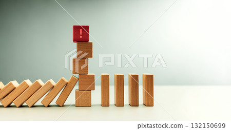 Red wooden block with exclamation mark standing among dominoes 132150699