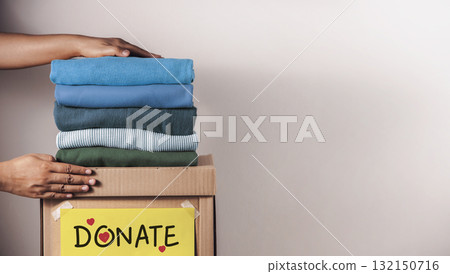 Clothes Donation, Renewable Concept.Hands folding and packing clothes into box at home 132150716