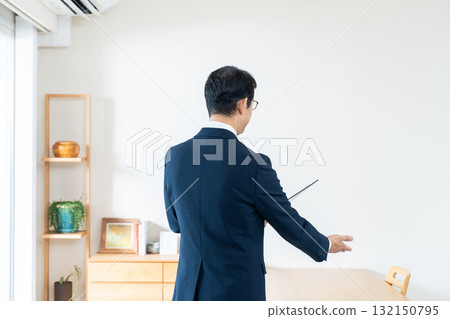 一名西裝革履的男子正在檢查家具 132150795