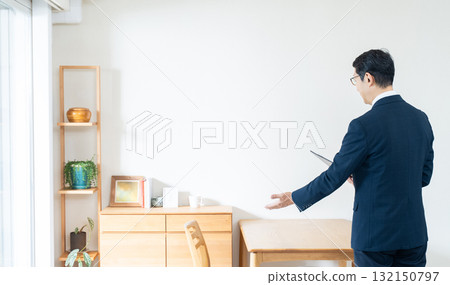 一名西裝革履的男子正在檢查家具 132150797