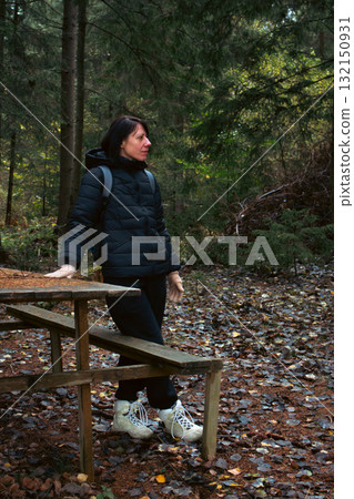 Girl in autumn forest. Young woman with backpack in mountain woodland. Active lifestyle concept. Hiking woman. Journey in Carpathian mountains, Ukraine. Tourist woman in woods. Explore the world. 132150931