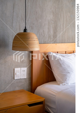 Cozy bedroom detail with wooden lampshade and concrete wall. Cozy bedroom detail with wooden lampshade and concrete wall. 132150964