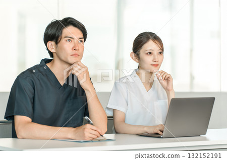 Male and female medical staff in scrubs attending medical conferences, study sessions, seminars, training sessions 132152191