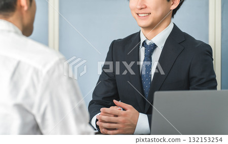 A young Asian businessman serving customers in a showroom or business meeting space A young Asian businessman serving customers in a showroom or business meeting space 132153254