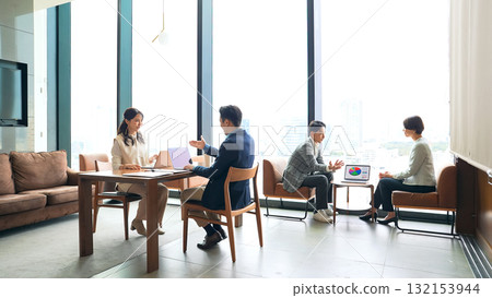 A group of casual business people meeting in a lobby A group of casual business people meeting in a lobby 132153944