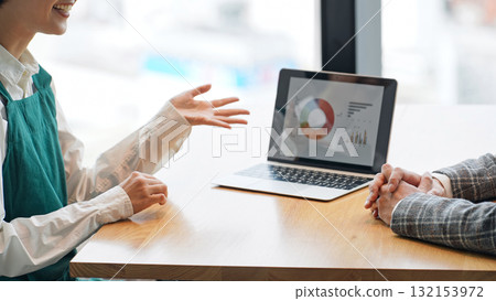 一位店員和一位商務人士在開會時看著筆記型電腦 一位店員和一位商務人士在開會時看著筆記型電腦 132153972