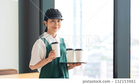 拿著紙杯的微笑的餐廳員工 拿著紙杯的微笑的餐廳員工 132153981