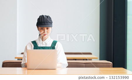 Restaurant clerk entering data on a laptop 132153990