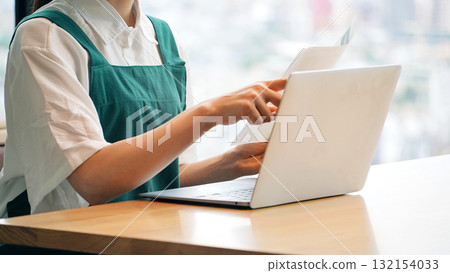 Restaurant clerk entering data on a laptop 132154033