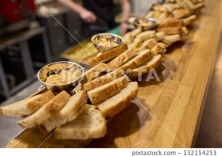 A beautifully arranged Assorted Bread Platter featuring a variety of Spreads on a Wooden Countertop A beautifully arranged Assorted Bread Platter featuring a variety of Spreads on a Wooden Countertop 132154253
