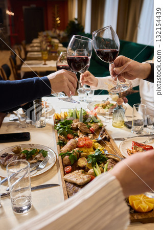Cheers to a Fantastic Celebration Friends Joyfully Toasting with Wine Glasses in Hand Cheers to a Fantastic Celebration Friends Joyfully Toasting with Wine Glasses in Hand 132154439