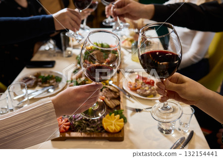 Cheers to a Fantastic Celebration Friends Joyfully Toasting with Wine Glasses in Hand Cheers to a Fantastic Celebration Friends Joyfully Toasting with Wine Glasses in Hand 132154441