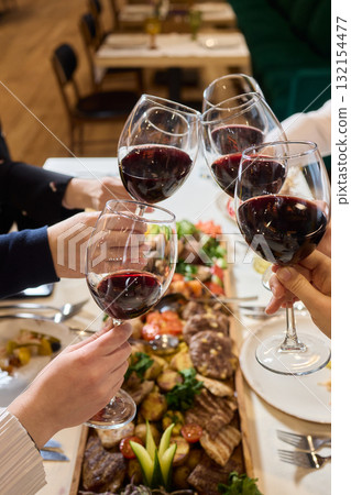 Cheers to a Fantastic Celebration Friends Joyfully Toasting with Wine Glasses in Hand Cheers to a Fantastic Celebration Friends Joyfully Toasting with Wine Glasses in Hand 132154477