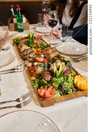 Indulge in an exquisite gourmet platter perfectly paired with a fine red wine selection 132154495