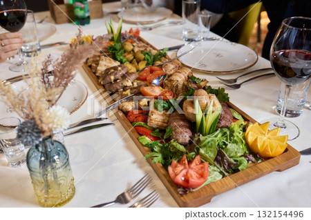 Indulge in an exquisite gourmet platter perfectly paired with a fine red wine selection 132154496