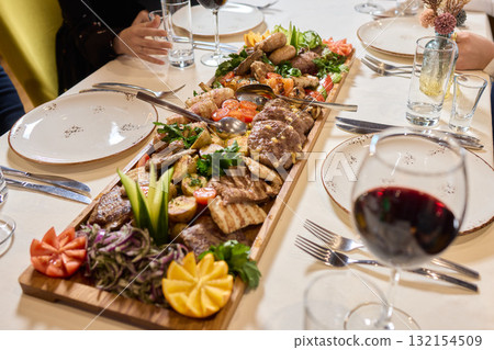 Indulge in an exquisite gourmet platter perfectly paired with a fine red wine selection 132154509