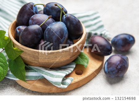 Fresh ripe plums filling a wooden bowl 132154698