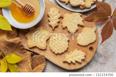 Autumn leaf cookies with honey on wooden board 132154700