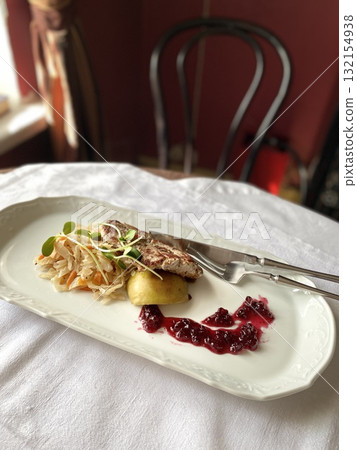 Gourmet dish with grilled chicken and berry sauce on elegant white plate in restaurant setting Gourmet dish with grilled chicken and berry sauce on elegant white plate in restaurant setting 132154938
