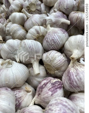 Garlic bulbs closely packed in a pile viewable from above as a textured background 132154950