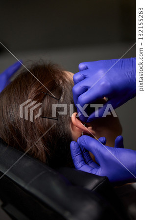 Professional Piercing Process A detailed closeup view showcasing the art of Ear Piercing Professional Piercing Process A detailed closeup view showcasing the art of Ear Piercing 132155263