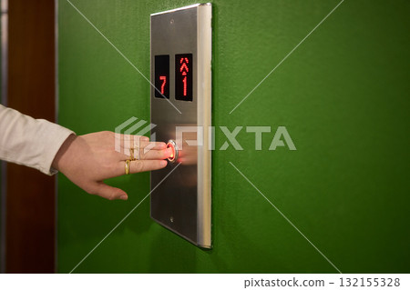 Pressing the elevator button in contemporary high rise buildings signifies modern urban convenience 132155328