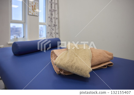 Experience the comfort of a beautifully designed blue massage table in our therapy room 132155407