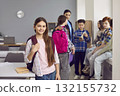 Portrait of happy girl elementary student standing with backpack 132155732