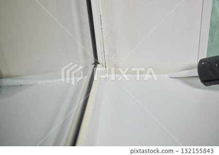 Sealing the corners of windows with caulk for achieving a perfectly neat and polished finish Sealing the corners of windows with caulk for achieving a perfectly neat and polished finish 132155843