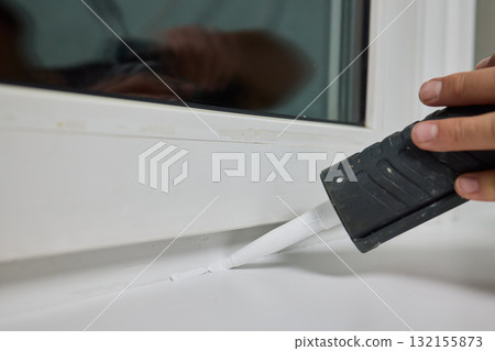 Sealing the corners of windows with caulk for achieving a perfectly neat and polished finish Sealing the corners of windows with caulk for achieving a perfectly neat and polished finish 132155873