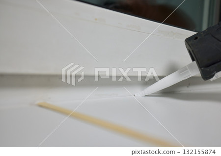 Sealing the corners of windows with caulk for achieving a perfectly neat and polished finish Sealing the corners of windows with caulk for achieving a perfectly neat and polished finish 132155874