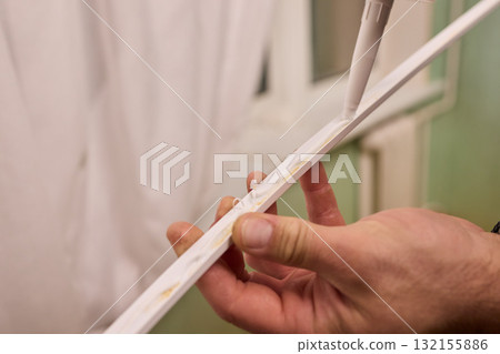 Hand Applying Adhesive with a Caulking Gun for Various Home Interior and Exterior Projects 132155886