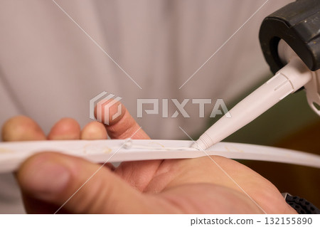Hand Applying Adhesive with a Caulking Gun for Various Home Interior and Exterior Projects Hand Applying Adhesive with a Caulking Gun for Various Home Interior and Exterior Projects 132155890